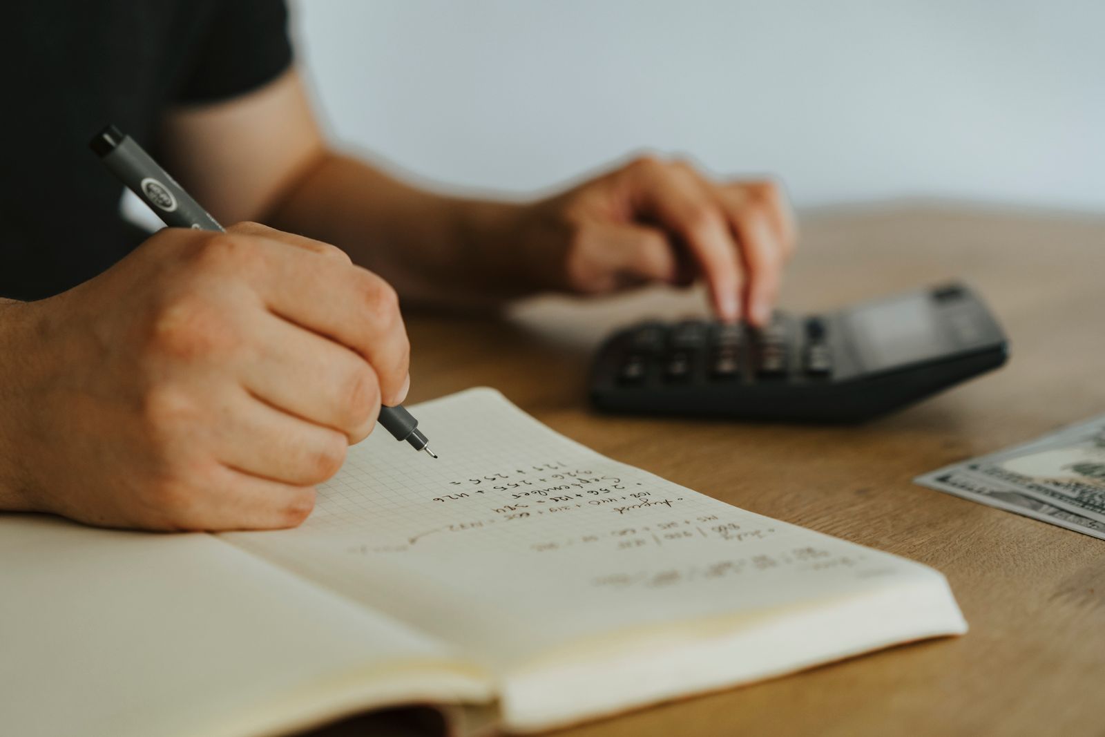 Personne faisant des calculs avec un carnet et un stylo