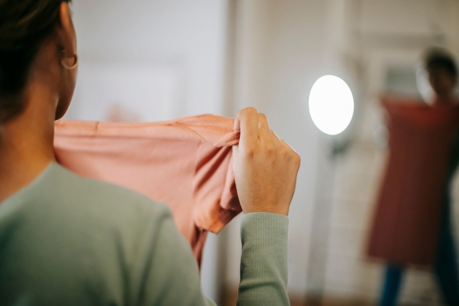 Personne essayant un vetement devant un miroir
